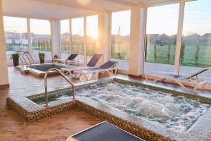 a large jacuzzi tub in a room with windows at Вілла Край неба in Zapson