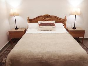 a bedroom with a large bed with two lamps at 10 Jock Meiring in Bloemfontein