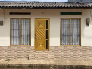 a house with a yellow door and three windows at Apartamento Lourdes 'parque principal ' in Necoclí