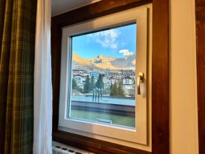 a window with a view of a city at Il nido delle Alpi in Passo del Tonale