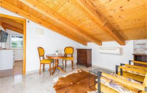 a kitchen and dining room with a table and chairs at Beautiful Home In Pomer in Pomer