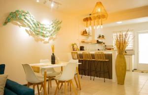 una sala da pranzo e una cucina con tavolo e sedie di Sunset Serenity a Flic-en-Flac