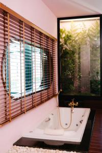 a bath tub in a bathroom with windows at The Sea-Cret Garden Hua Hin in Hua Hin