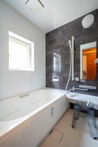 un bagno bianco con vasca e lavandino di Best View a Nakafurano