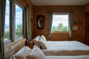 a bedroom with two beds in a room with windows at Best View in Nakafurano +159 photos