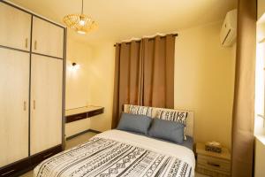 una piccola camera da letto con un letto e uno specchio di Sunset Serenity a Flic-en-Flac