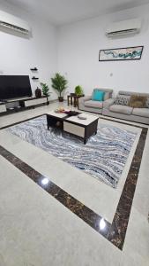 un salon avec un canapé et un tapis dans l'établissement استراحة الهولي, à Ma‘mūrah