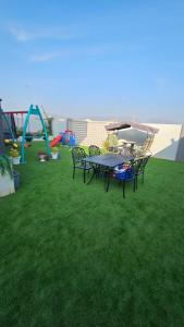- un parc avec une table de pique-nique et une aire de jeux dans l'établissement استراحة الهولي, à Ma‘mūrah