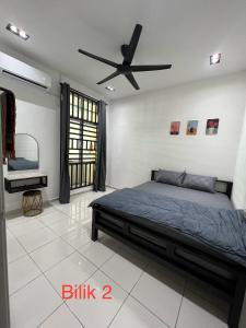 a bedroom with a bed and a ceiling fan at Meera Homestay in Melaka