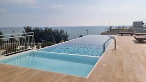 a swimming pool with a view of the ocean at Mosaic condominium AD63M in Ban Tha Fat