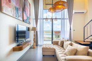 een woonkamer met een bank en een tv bij Santos Suites in Badung