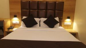 a bedroom with a large bed with black pillows at Hotel Hoxton in Mumbai