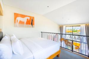 een slaapkamer met een bed en een balkon bij Santos Suites in Badung