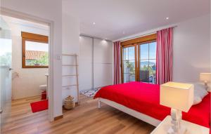 a bedroom with a red bed and a window at 3 Bedroom Lovely Home In Kostrena in Kostrena