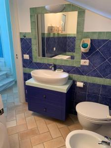 a bathroom with a sink and a toilet and a mirror at Casa MaTu in Nettuno