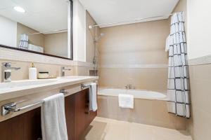 Un baño con bañera, lavabo y espejo. en Luxury 2BR Skyline Sea View Direct Mall Metro Dining Shops City Walk, en Dubái 40 fotos más
