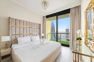 Un dormitorio con una gran cama blanca y una gran ventana. en Luxury 2BR Skyline Sea View Direct Mall Metro Dining Shops City Walk, en Dubái