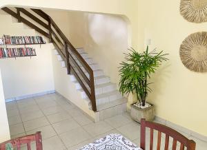 eine Treppe in einem Wohnzimmer mit Topfpflanze in der Unterkunft Sobrado piscina a 200m orla, perfeito para festa in Paulista