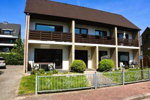 a house with a fence in front of it at Strandkiesel in Büsum +2 photos