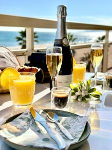 a table with a bottle of champagne and glasses of orange juice at Suite Balnéo Canet in Canet-en-Roussillon +36 photos