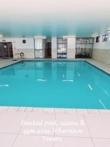 a large swimming pool with blue lighting in a building at Hibernian Towers 309 Strand - Luxury Self Catering in Cape Town