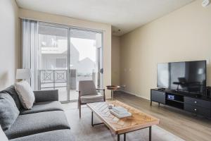 a living room with a couch and a tv and a table at Blueground Burbank 1bd apartment LAX-1275 in Los Angeles