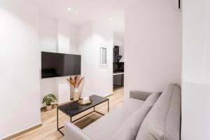 a white living room with a couch and a table at Alma Suite - close to Acropolis in Athens +3 photos