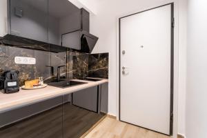 a kitchen with a white door and a counter with a sink at Alma Suite - close to Acropolis in Athens
