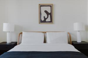 纽约Blueground Long Island City 1bd apartment NYC-1612的一张带两盏灯的床,上面有一张照片 更多35张照片