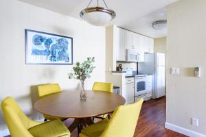 a kitchen and dining room with a table and yellow chairs at Blueground Santa Clara pool nr tech hub shops SFO-1672 in Santa Clara