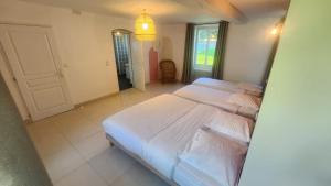a large bedroom with two beds and a mirror at Chambres Domaine de Saint Marc in Saint-Médard