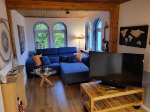 a living room with a blue couch and a flat screen tv at Wunderschöne Wohnungen im Zentrum von Herzogenaurach in Herzogenaurach