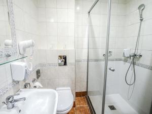 a bathroom with a shower and a toilet and a sink at Holiday Beach Budapest Wellness Hotel with Sauna Park in Budapest