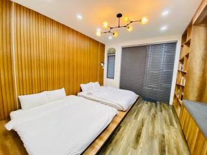a bedroom with two beds and a book shelf at Villa nguyên căn 4 phòng ngủ, cạnh biển Thuận An Rabbit Home Villa in Phú Vang