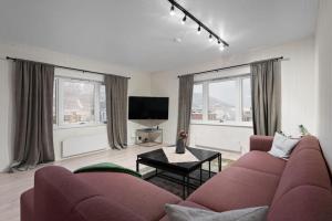 a living room with a couch and a tv at BraMy Apartments The Cozy View in Tromsø