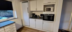 a kitchen with white cabinets and a microwave at Venos Home 2 in Lemvig