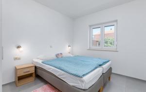 a white bedroom with a bed and a window at Ferienhaus Anton in Peroj