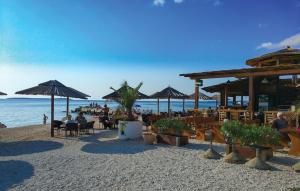 a beach with people sitting in chairs and umbrellas at Ferienhaus Anton in Peroj