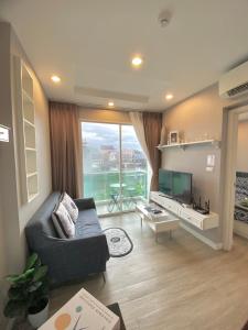 a living room with a couch and a television at Lucky Room in Ban Bang Saen (1)