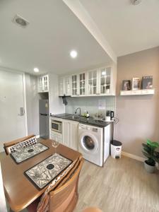 a kitchen with a table and a washing machine at Lucky Room in Ban Bang Saen (1)