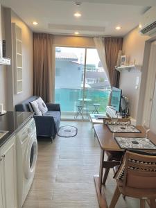 a living room with a couch and a table with a washing machine at Lucky Room in Ban Bang Saen (1) +2 photos