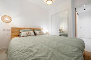 a white bedroom with a large bed and a mirror at Appartement Cambrils front de mer in Cambrils +18 photos
