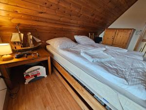 Un dormitorio con una cama grande en una habitación de madera. en Ferienhaus Seewiefken, en Hooksiel 2 fotos más