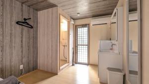 a room with a kitchen with a refrigerator and a counter at 与那国むんぶステイ祖納 in Sonai