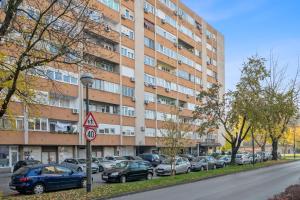 a large building with cars parked in a parking lot at Studio Apartment Pulse Zagreb Knezija in Zagreb