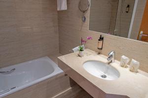 康达Hotel Faranda Marsol Candas, Ascend Hotel Collection的带水槽和浴缸的浴室