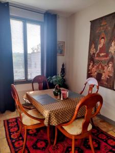 une salle à manger avec une table et quatre chaises dans l'établissement Au Gré Du Voyage, à Uzès
