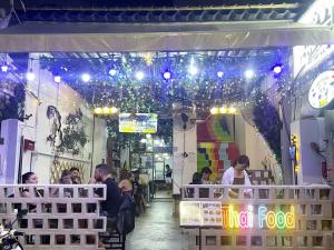 a group of people sitting at a restaurant with lights at Panda Lodge Home Stay in Bangkok