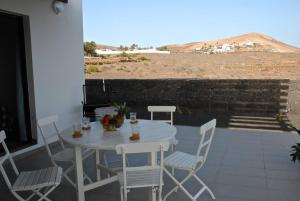 biały stół i krzesła na patio w obiekcie EL TUCAN, Vistas en 3 dormitorios y piscina w mieście Nazaret