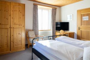 a bedroom with a bed and a desk and a window at Golf Hotel Des Alpes in Samedan